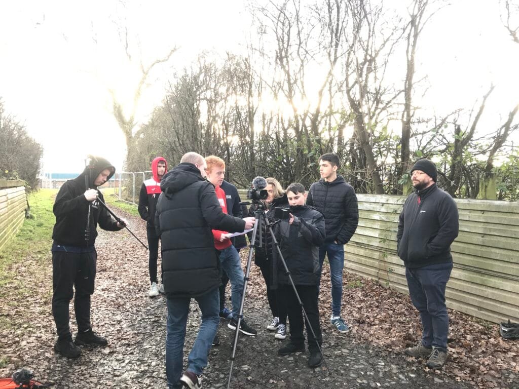 group of young adults outside with digital media kit